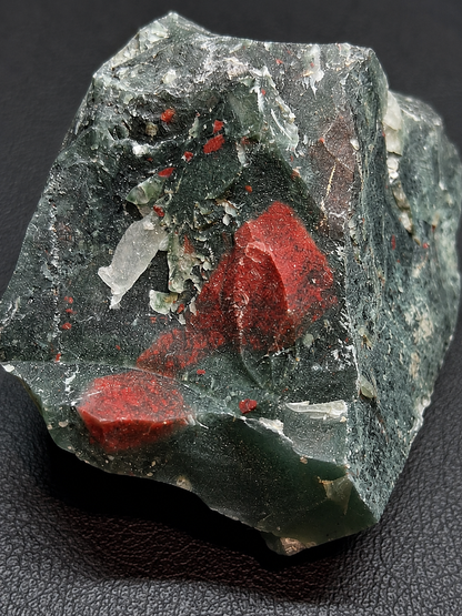 Mineral sample with red and black minerals on a dark background