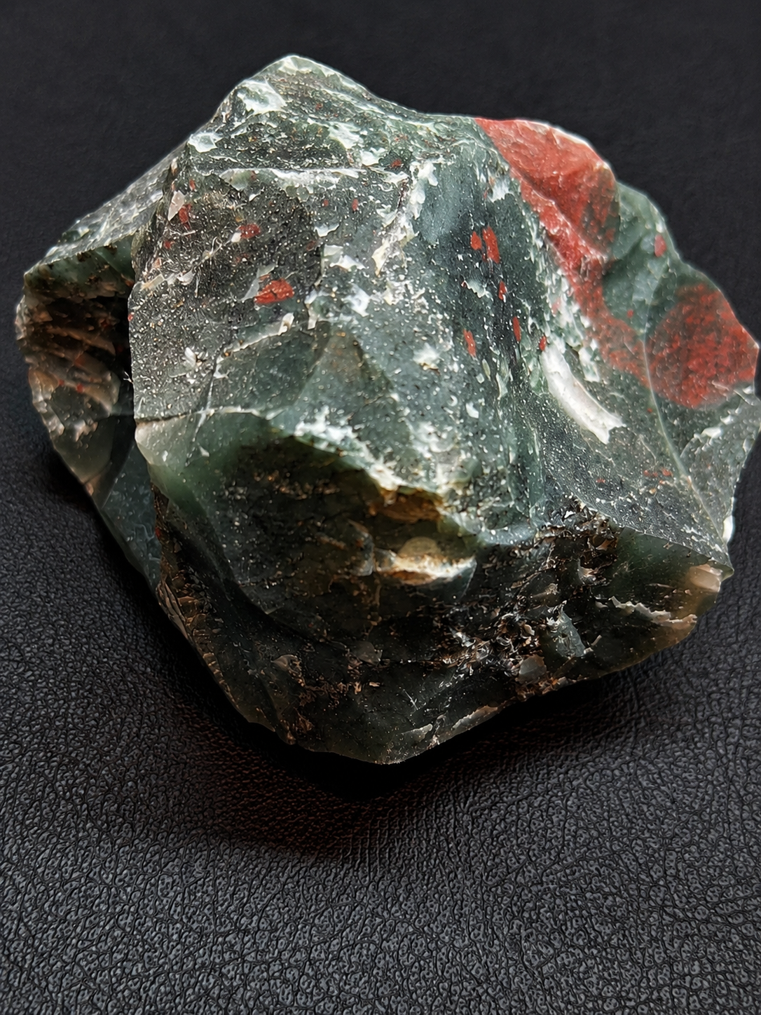 Mineral specimen with green and red colors on a dark background