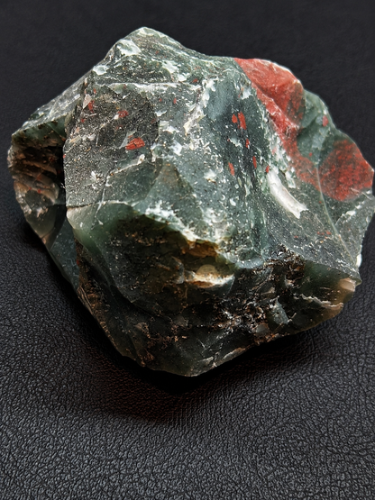 Mineral specimen with green and red colors on a dark background
