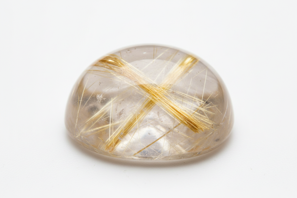 Cabochon rutile quartz white background