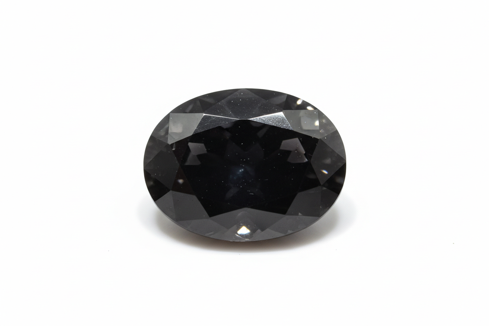 faceted black spinel oval cut white background