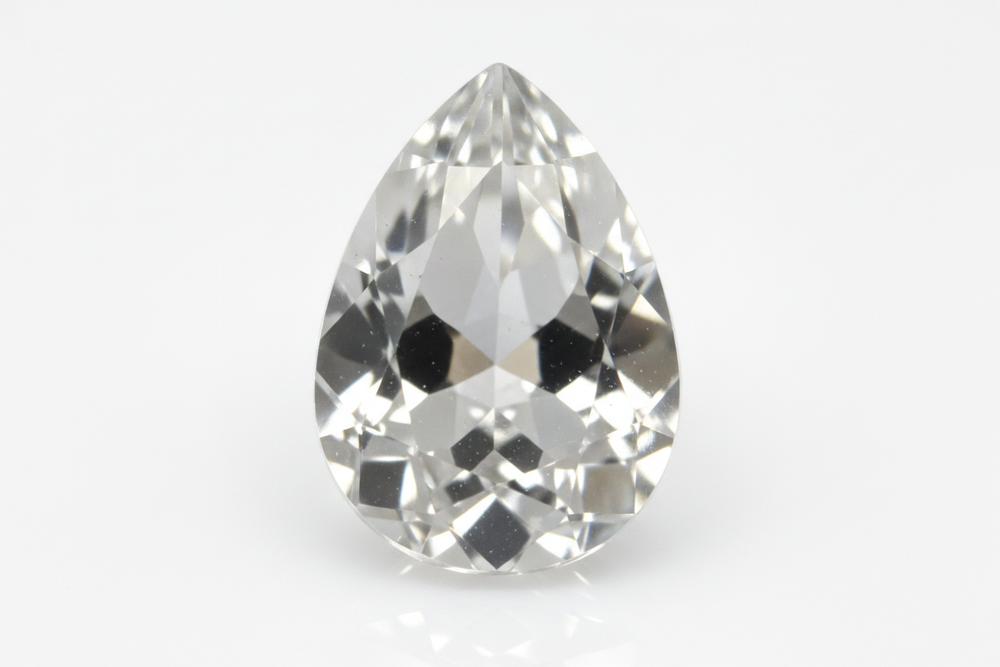 faceted goshenite gemstone pear shaped white background