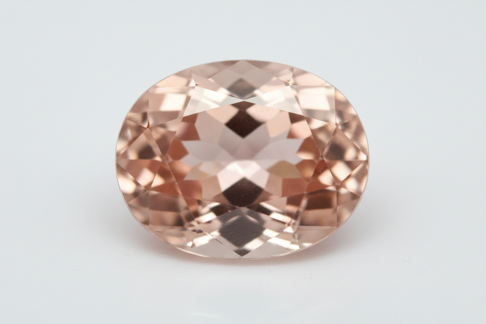 Faceted morganite gemstone oval cut white background