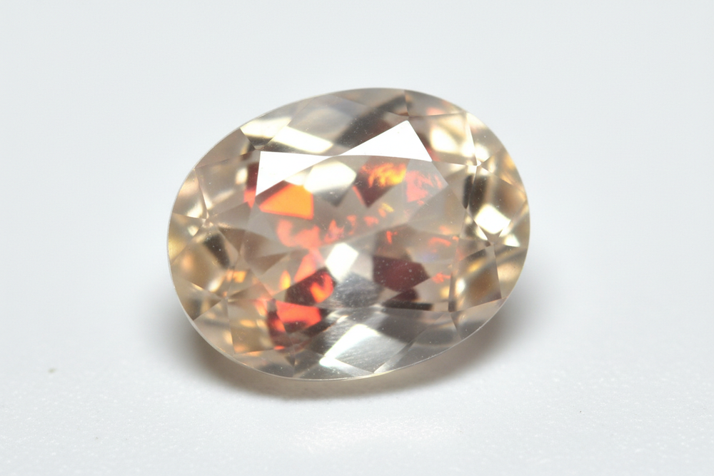 faceted white opal with play of fire oval cut white background